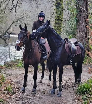 Bryony riding Frodon with Black Corton besides the River Dart. Credit: Bryony Frost