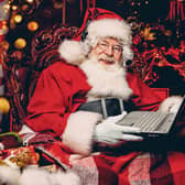 A portrait of Santa Claus sitting at his home with a laptop. Miracle time. Christmas, New Year.