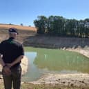 An Environment Agency officer at a farming reservoir experiencing very low water levels earlier this month